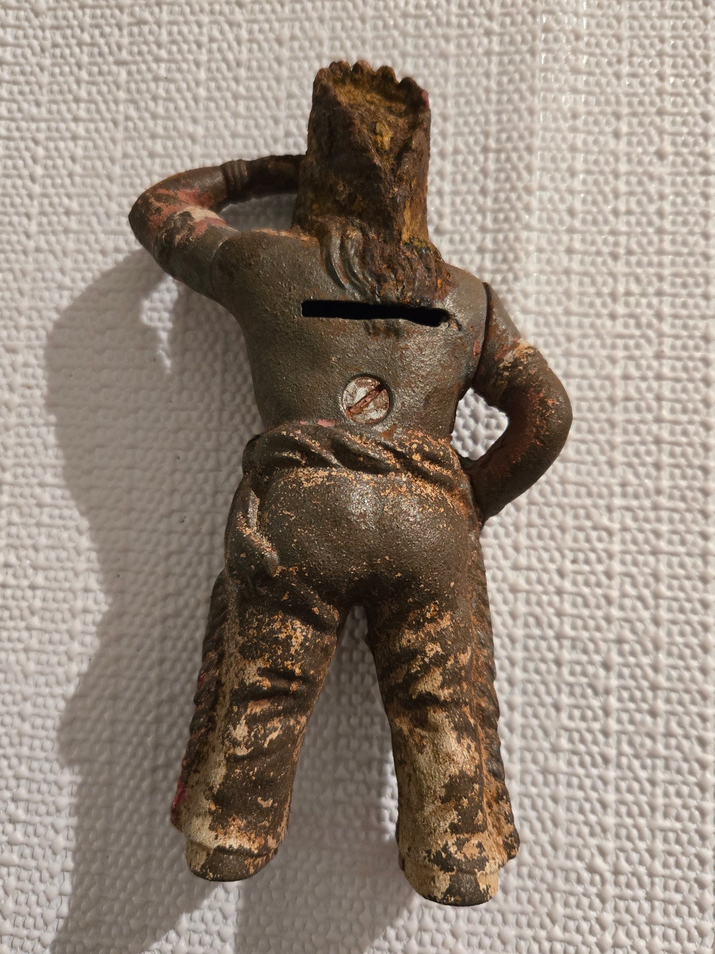 Back of cast iron Native American bank with coin slot and rust