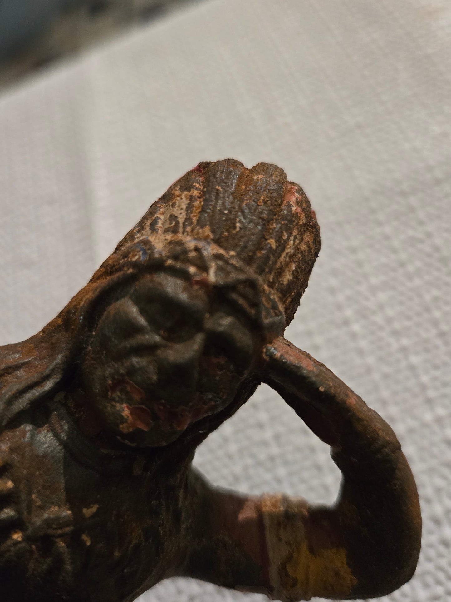 Cast iron Native American with headdress looking out with hand above brow