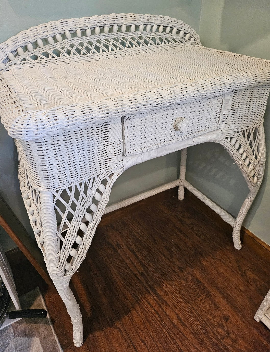Beautiful vintage white wicker desk with bowed legs and single drawer.