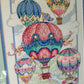 Upclose picture of framed cross stitch hot air balloons wall decor.