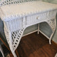 Beautiful vintage white wicker desk with bowed legs and single drawer.